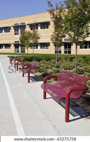 Several empty outdoor benches by an elementary school building in Whitehall, Pennsylvania.