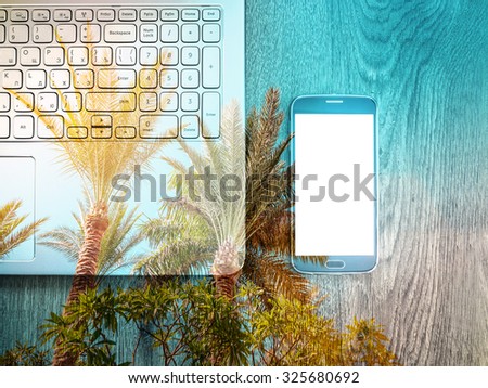 Double exposure of smartphone with Blank screen with laptop on table. Palms on background. Wooden texture