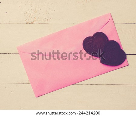 Chocolate heart with letter paper on the wooden background,vintage color toned image
