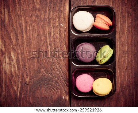French colorful mini macarons on wood table,vintage color toned image