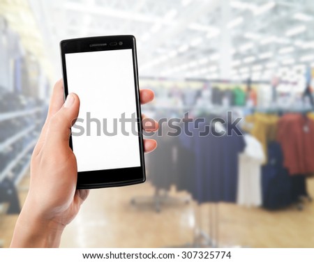 hand holding mobile smart phone touch screen in clothing store