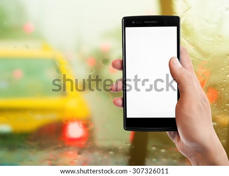Hand holding smart phone on traffic jam background.