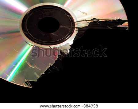 A broken compact disk against a black background.