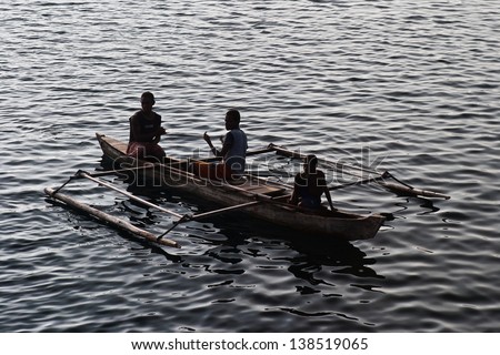 A trio of fishermen prepare hand lines in their outrigger canoe in a remote location in eastern Indonesia. Shallow marine habitats support over 100 million people in southeast Asia.