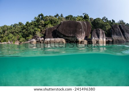 Warm, tropical water bathes the rocky shore of a remote island in the Mergui Archipelago off the coast of Myanmar. These beautiful islands in the Andaman Sea are rarely visited.