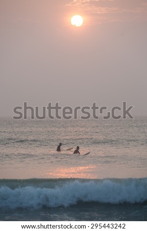 Surfers wait for a set of waves off the coast of Cape Cod, Massachusetts. The beaches of Cape Cod provide a nice place to learn to surf though Great White sharks hunt seals in these same waters.