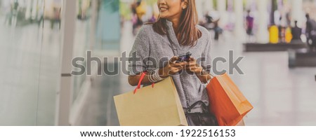 Banner cover of Asian woman using the smart mobile phone for check online shopping order with clothes beside the glassess in store shop at department center,shopaholic and fashion concept Сток-фото © 