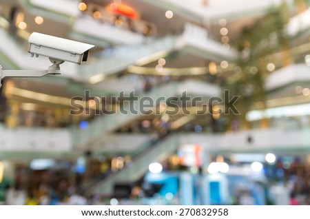 CCTV security camera on monitor the Abstract blurred photo of escalator with people in department store bokeh background