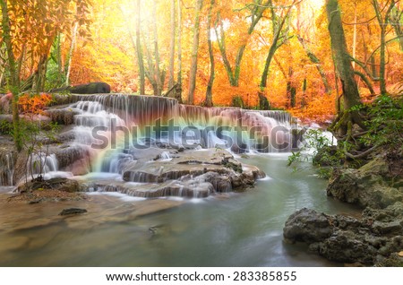 Beautiful waterfall in the deep forest with rainbow in soft focus