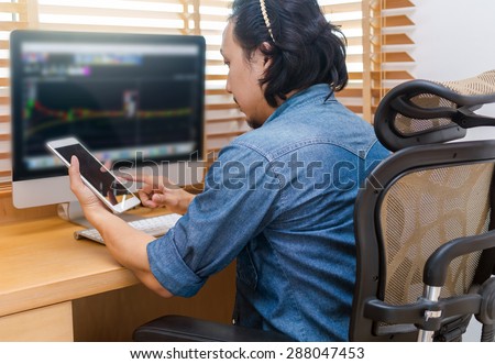 Grapphic designer working at Workplace with computer, tablet, smart phone and key board on wooden table