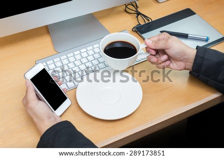 Businessman working at Workplace with computer, tablet, smart phone, key board and coffee cup on wooden table