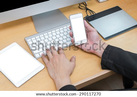 Businessman working at Workplace with computer, tablet, smart phone, key board and coffee cup on wooden table