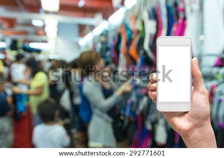 Female hand holding mobile smart phone touch screen on Abstract blurred photo of store blur with customer choose product bokeh background