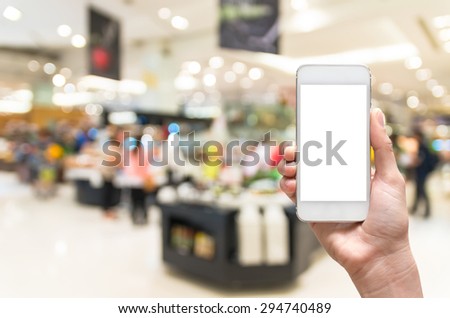 Female hand holding mobile smart phone on salad bar store blur background, business concept
