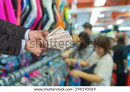 Businessman offered the money on the Abstract blurred photo of store blur with customer choose product bokeh background