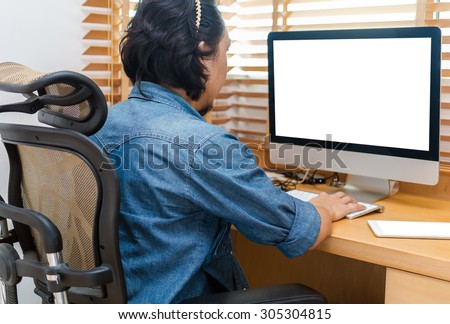 Graphic designer working at Workplace with computer, tablet, smart phone and key board on wooden table