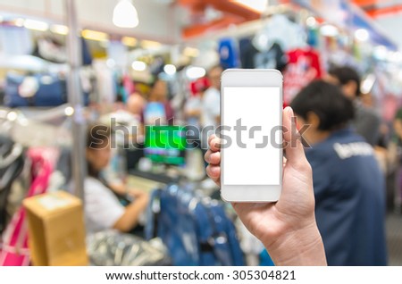 Female hand holding mobile smart phone touch screen on Abstract blurred photo of cashier store blur with bokeh background