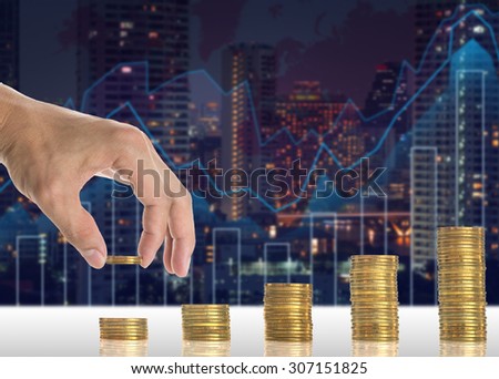 Hand putting the gold coins on the stack of golden coins on Trading graph on the cityscape blurred background, Business financial concept