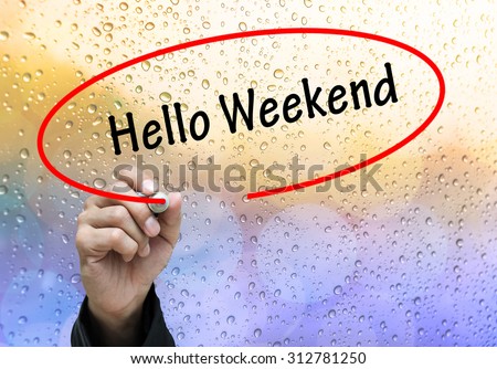 Man Hand writing Hello Weekend by black marker on visual screen. Business concept