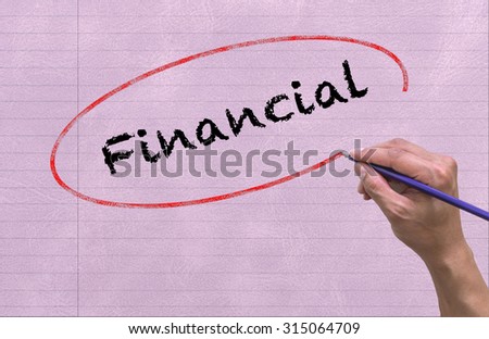 Hand writing Financial by pencil on paper Notebook background. Business and Education concept
