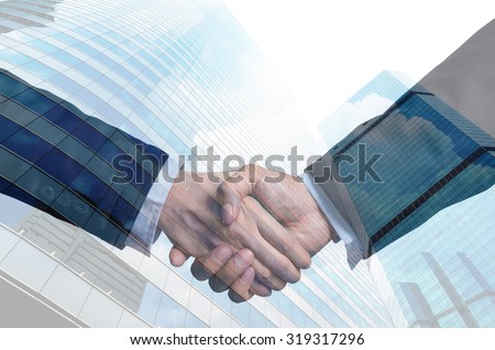 double exposure handshake between businessman on Modern glass building background