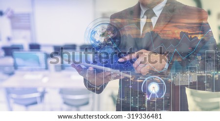 Double exposure of businessman using the tablet with cityscape and financial graph which have earth and world map on computer blurred background, Elements of this image furnished by NASA