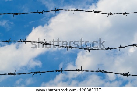 Barbed wire line with blue sky and white cloud