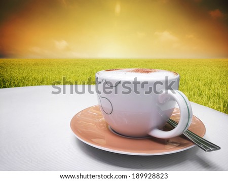 Cappuccino coffee with paddy rice field background