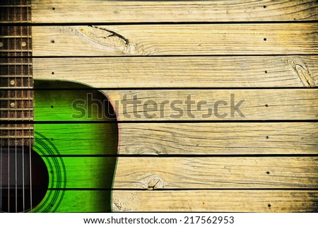 green acoustic guitar art on wooden wall