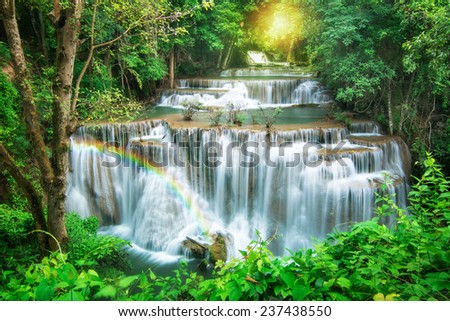 Huay Mae Khamin waterfall with rainbow in deep forest of national park, Thailand
