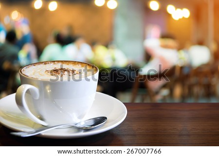 Cup of cappuccino with blur coffee shop background