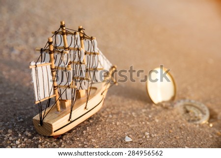 Sailing ship model with compass on the beach