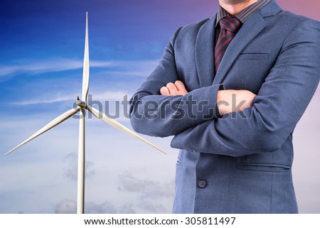 Business man in suit on wind turbine for electricity background