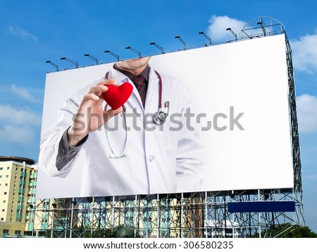 doctor holding red heart shape on billboard with white space