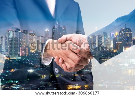 Photo of Double exposure of business handshake for successful of investment deal and city night background, teamwork and partnership concept. 