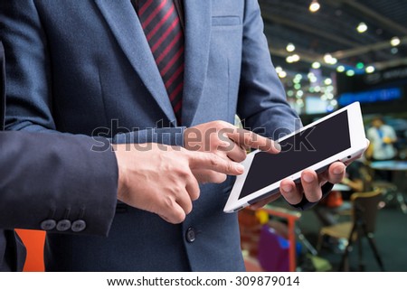 Image of two businessmen using tablet at meeting with blur people in food center background