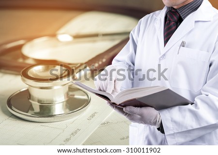 Doctor reading text book with stethoscope background