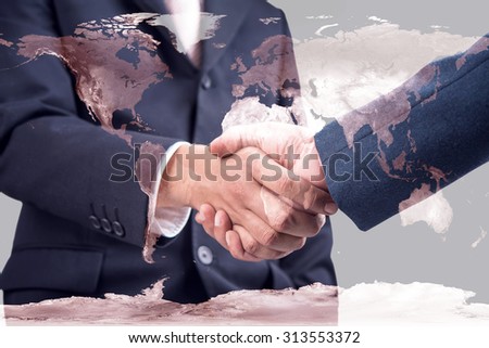 Double exposure of handshake on world map. Elements of this image furnished by NASA.