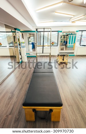 Pilates room having the equipment ready for clients. Focus on trapeze table.