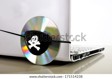 Pirate Eye patch on cd or dvd disk and computer representing piracy, illegal download and copyright violation