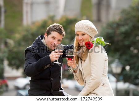 young man giving his girlfriend a rose and kissing celebrating valentines day