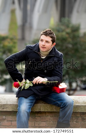 vertical portrait of a man with chocolates and a rose being stood by his girlfriend on valentines day