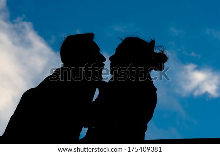 young couple in silhouette holding a love heart shape pillow
