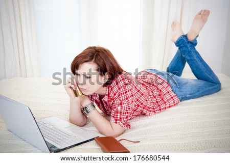 red haired student business woman wearing a red shirt worried after online shopping on white background