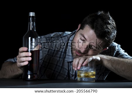 close up portrait of alcoholic wasted man sleeping drunk looking at whiskey glass avoiding temptation thinking of alcohol addiction , drinking abuse , alcoholism concept isolated on black background