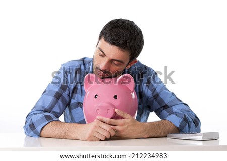 young attractive broke man worried in stress feeling sad hugging empty pink piggy bank in bad financial situation concept wearing casual shirt isolated on white background