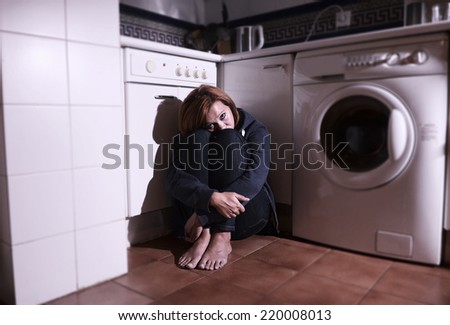 lonely scared and sick woman sitting on kitchen floor in stress , depression and sadness feeling miserable holding his legs in barefoot looking desperate