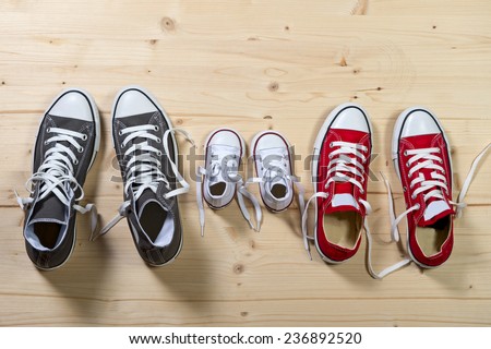 three pair of shoes in father big, mother medium and son or daughter small kid size representing family, growth, education and togetherness concept