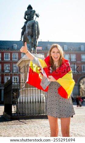 young happy attractive exchange student girl having fun in town visiting Madrid city showing Spain flag having fun outdoors in tourism and travel vacation concept