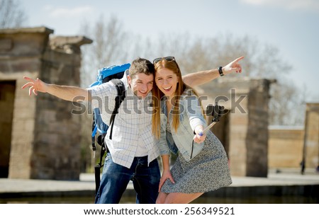 young American student and tourist couple visiting Egyptian monument taking selfie photo with stick carrying expedition backpack in holiday tourism and vacation travel concept